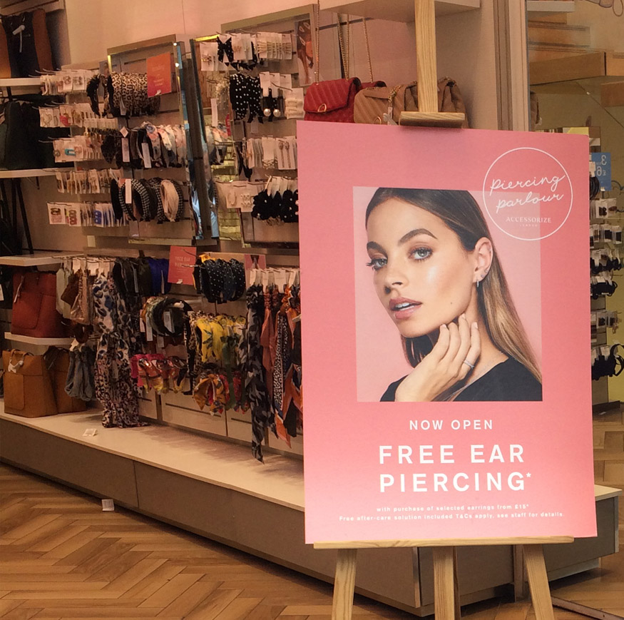 Sign offering free ear piercing at Accessorize shop on London's Oxford Street